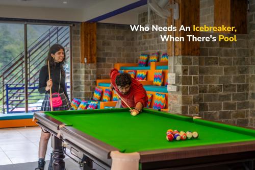 a woman standing next to a man playing pool at goSTOPS PLUS Kasol, Suma Ropa in Kasol