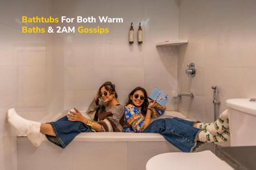 two women sitting in a bath tub reading books at goSTOPS PLUS Kasol, Suma Ropa in Kasol