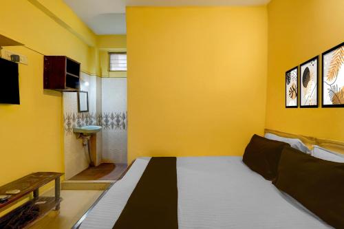 a yellow room with a bed and a yellow wall at Hotel O Egmore Metro Station Chennai Formerly Harini Lodge in Chennai