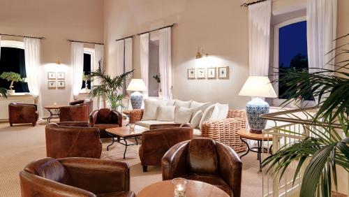sala de estar con sofá, sillas y mesas en Precise Resort Rügen & SPLASH Erlebniswelt, en Sagard
