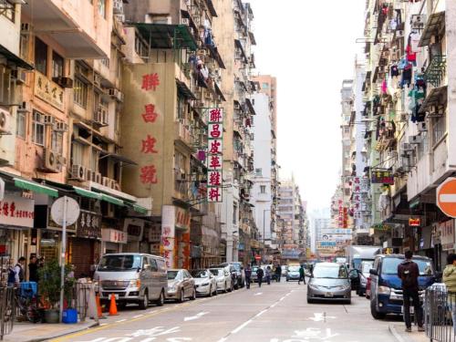 a busy city street with cars parked on the street at Metroplace Boutique in Hong Kong