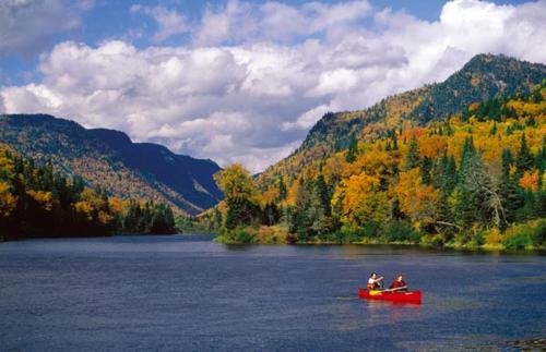 two people in a red boat on a lake at Gîte Parc Mauricie B&B in Saint Mathieu Du Parc