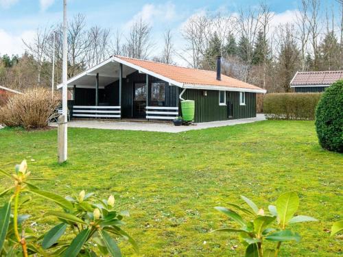 a small green house with a grass yard at 4 person holiday home in Toftlund in Toftlund