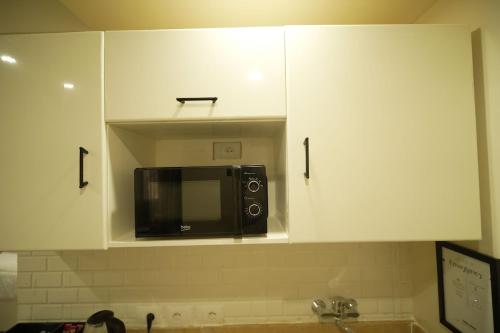 a microwave sitting on top of a kitchen cabinets at modern studio- 7 min from aswan station in Aswan