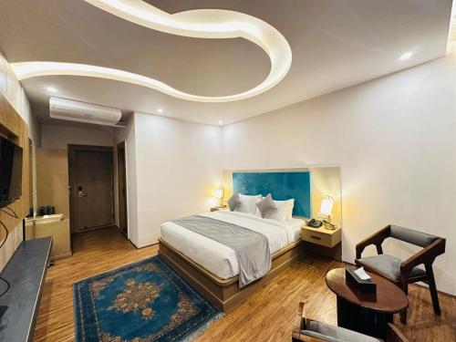 a hotel room with a bed and a chair at The Pahalgam Dayz in Pahalgām
