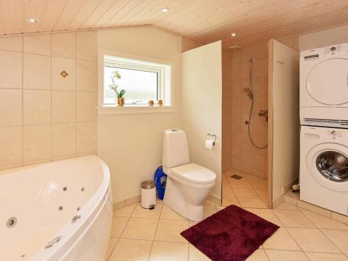 a bathroom with a tub and a toilet and a sink at Secluded Retreat in Nature - By Traum Ferienwohnungen in Lønne Hede