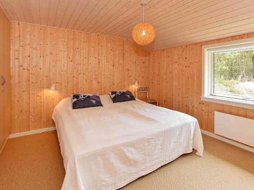 a bedroom with a white bed with a window at Secluded Retreat in Nature - By Traum Ferienwohnungen in Lønne Hede