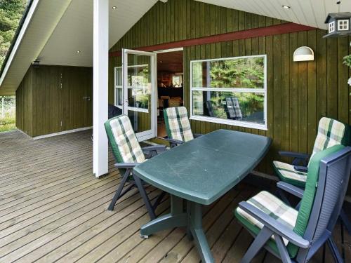 a green table and chairs on a deck at Secluded Retreat in Nature - By Traum Ferienwohnungen in Lønne Hede