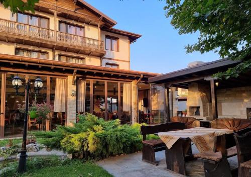 a patio in front of a building with a table at Rodopska Kushta in Asenovgrad