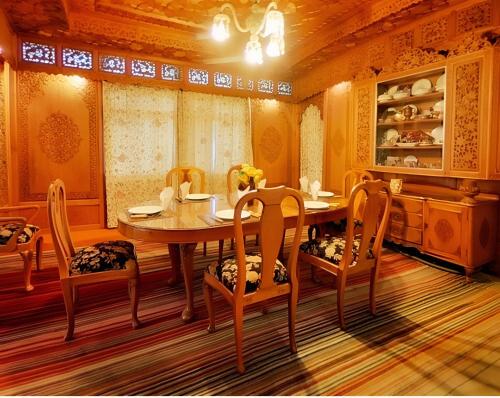 a dining room with a wooden table and chairs at The Royal hareem group of houseboats in Srinagar