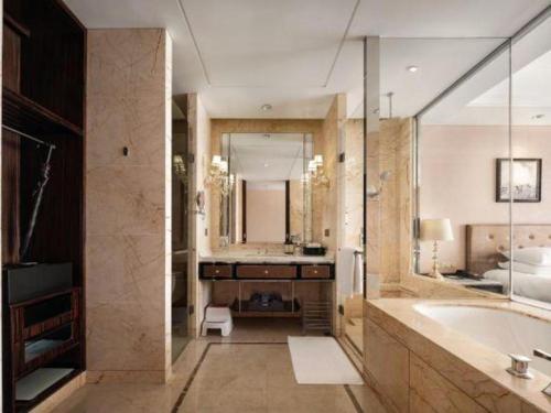 a bathroom with a large tub and a large mirror at Dongwu New Century Grand Hotel Huzhou in Huzhou