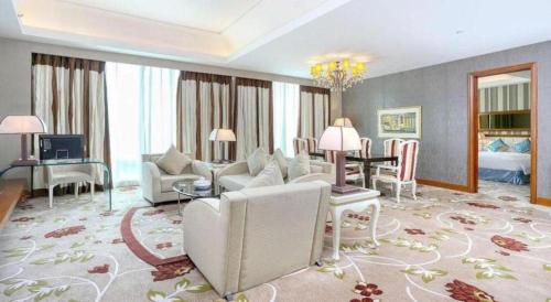 a living room with a couch and a dining room at Regency Hotel in Shantou
