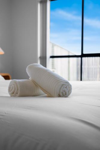 a rolled up towel sitting on top of a bed at Whispering Pines - Stylish 3BR Duplex close to M1 in Pimpama