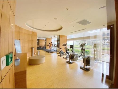 ein Fitnessstudio mit Laufbändern und Crosstrainern in einem Gebäude in der Unterkunft The Branz BSD city luxurious and cozy apartment in Samporo