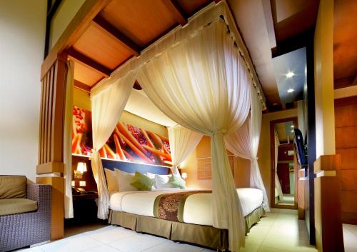 1 dormitorio con 1 cama con dosel en The Banyumas Villa en Denpasar