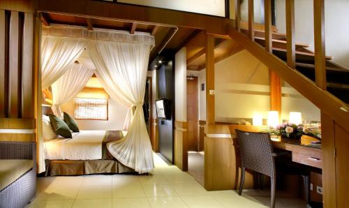 ein Schlafzimmer mit einem Bett und einem Schreibtisch in einem Zimmer in der Unterkunft The Banyumas Villa in Denpasar