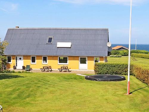 a yellow house with a trampoline in front of it at 10 person holiday home in Vinderup-By Traum in Vinderup
