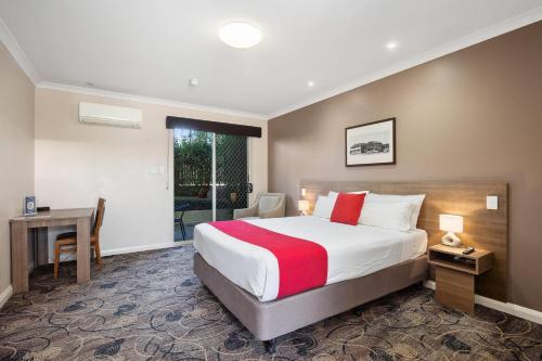 a hotel room with a bed and a desk at Quality Hotel Bayswater in Perth