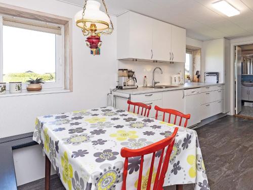 a kitchen with a table and two chairs and a table and a tablecloth on at 10 person holiday home in Vinderup-By Traum in Vinderup