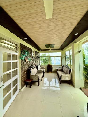 a living room with couches and a stone wall at Ambler Spaces in Banethi
