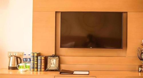 a flat screen tv hanging on a wall at GreenTree Inn Xi'an Yanta District Dayanta Furongyuan Hotel in Xi'an