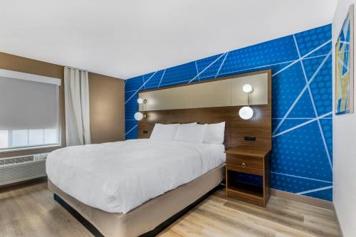 a bedroom with a large bed and a blue wall at Comfort Inn & Suites Ogallala in Ogallala