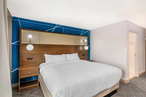a bedroom with a large bed and a blue wall at Comfort Inn & Suites Ogallala in Ogallala