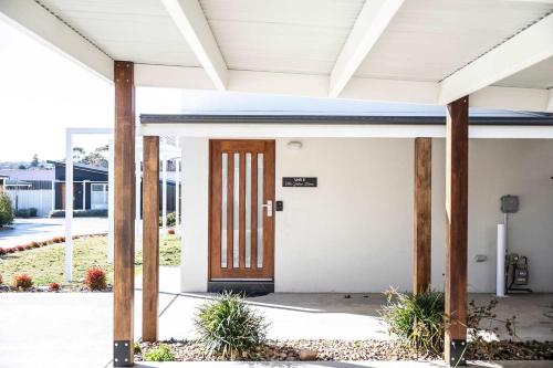 a front door of a house with pillars at The Elm Apartments - The Yellow Room in Orange