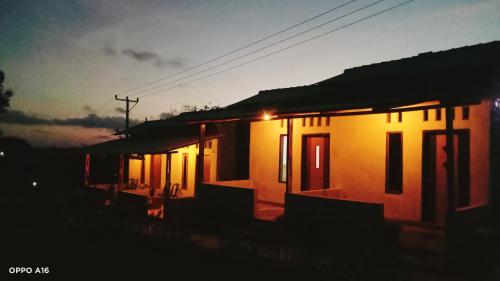 a row of houses with the lights on at sunset at Twins Homestay ekas in Pulau Gilkaliantan