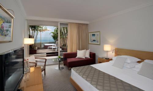 a hotel room with a bed and a living room at Royal Beach Eilat by Isrotel Exclusive in Eilat