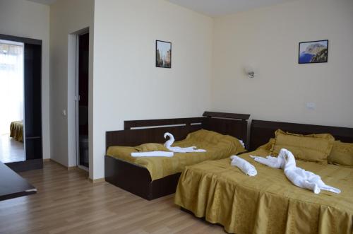 two beds with swans on them in a room at Vila Julia Costinesti in Costinesti