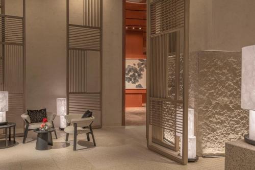a lobby with chairs and tables and a glass door at Four Seasons Hotel Osaka in Osaka