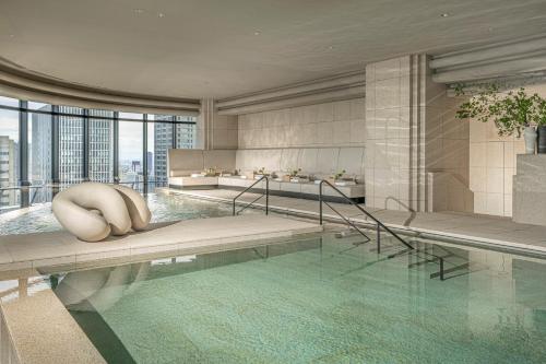 a swimming pool in a building with a poolvisorvisorvisorbiddenbidden at Four Seasons Hotel Osaka in Osaka
