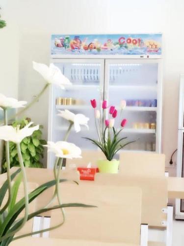 an open refrigerator with flowers in front of it at Jian Guo Grand Hotel in Vientiane
