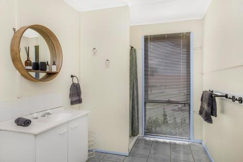 a white bathroom with a sink and a mirror at French Island General Store 