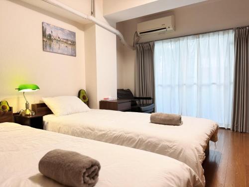 a hotel room with two beds and a window at Home Stroy in Tokyo-VENTI Okachimachi 東京屋語 in Tokyo