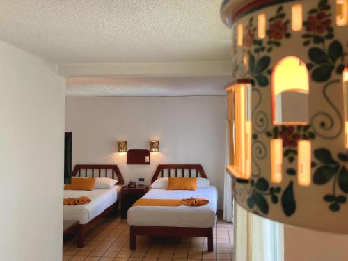 une chambre d'hôtel avec deux lits dans une chambre dans l'établissement Hotel Maya Palenque, à Palenque