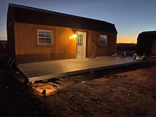 a house with a deck in front of it at Glitter and Grit! The Wild West 40 Homestead in Cane Beds