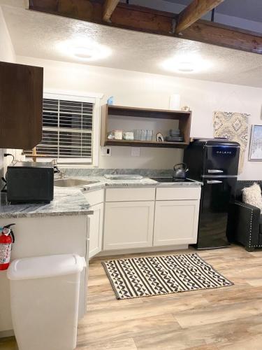 a kitchen with white cabinets and a counter top at Glitter and Grit! The Wild West 40 Homestead in Cane Beds