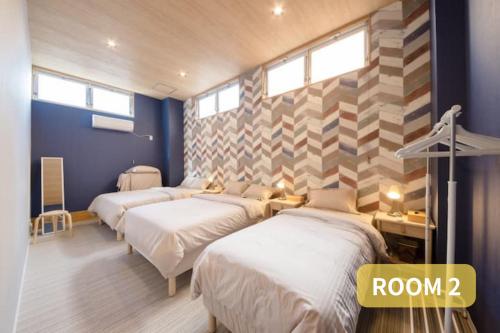 a room with four beds and a wall with windows at MORIHIRO Building in Ichikawa