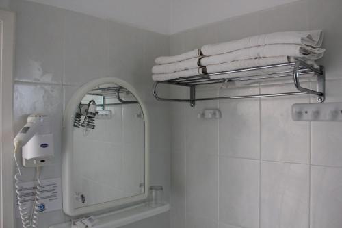 a white bathroom with a mirror and towels at Maria Rooms in Agia Ermioni