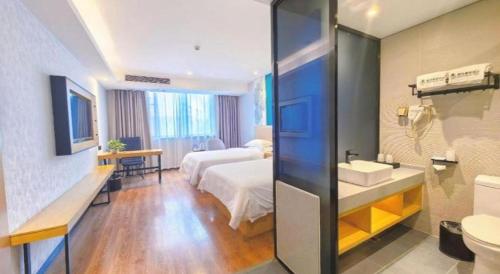 a hotel room with a bed and a bathroom at GreenTree Inn Ganzhou Gan County Bus Station in Ganzhou