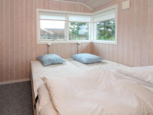 a bedroom with two beds and two windows at 8 person holiday home in Hadsund in Hadsund
