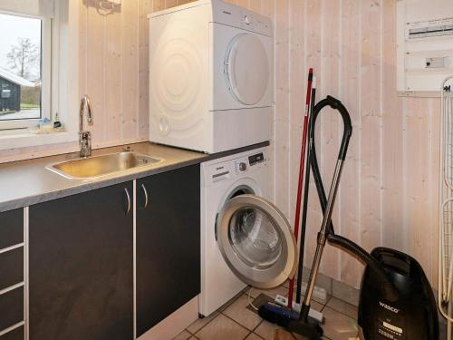 a kitchen with a washing machine and a sink at 8 person holiday home in Hadsund in Hadsund