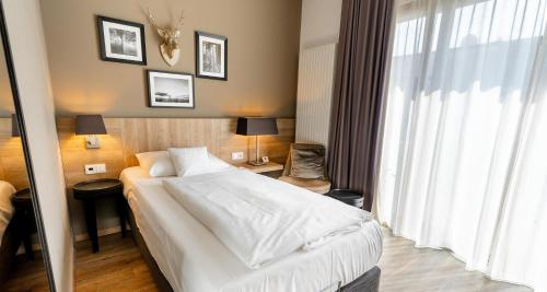a hotel room with a bed and a large window at Best Western Plus Hotel Ostertor in Bad Salzuflen