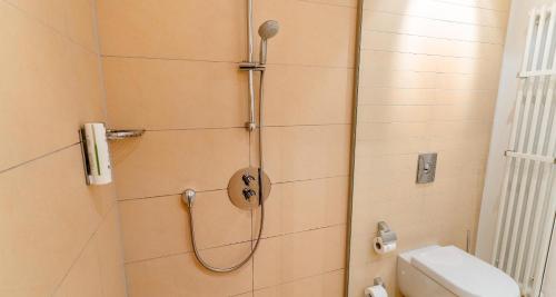 a bathroom with a shower with a toilet and a sink at Best Western Plus Hotel Ostertor in Bad Salzuflen
