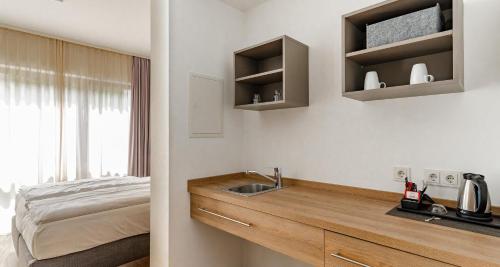a bathroom with a sink and a bed at Best Western Plus Hotel Ostertor in Bad Salzuflen