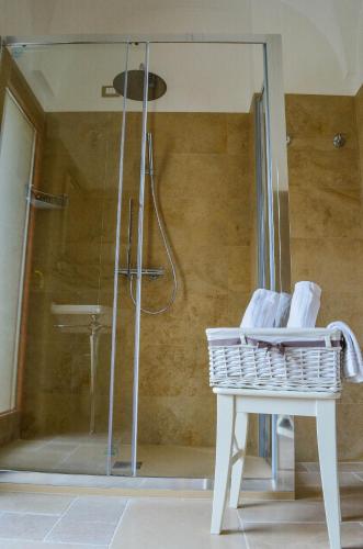 a bathroom with a shower with a white table and a glass shower stall at Hotel Masseria Tutosa in Ostuni