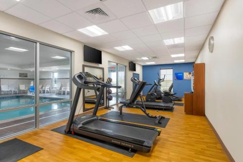 a gym with cardio machines and a swimming pool at Comfort Suites West Omaha in Omaha