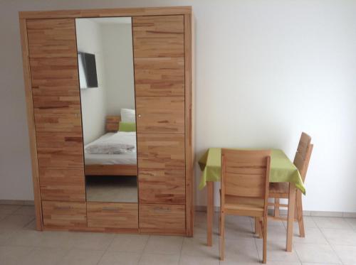 a wooden partition with a table and a mirror at Boardinghouse Casita Amann in Friedrichshafen